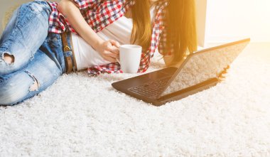 evde oturma odasında teleworking için dizüstü bilgisayar kullanan katta oturan kadın