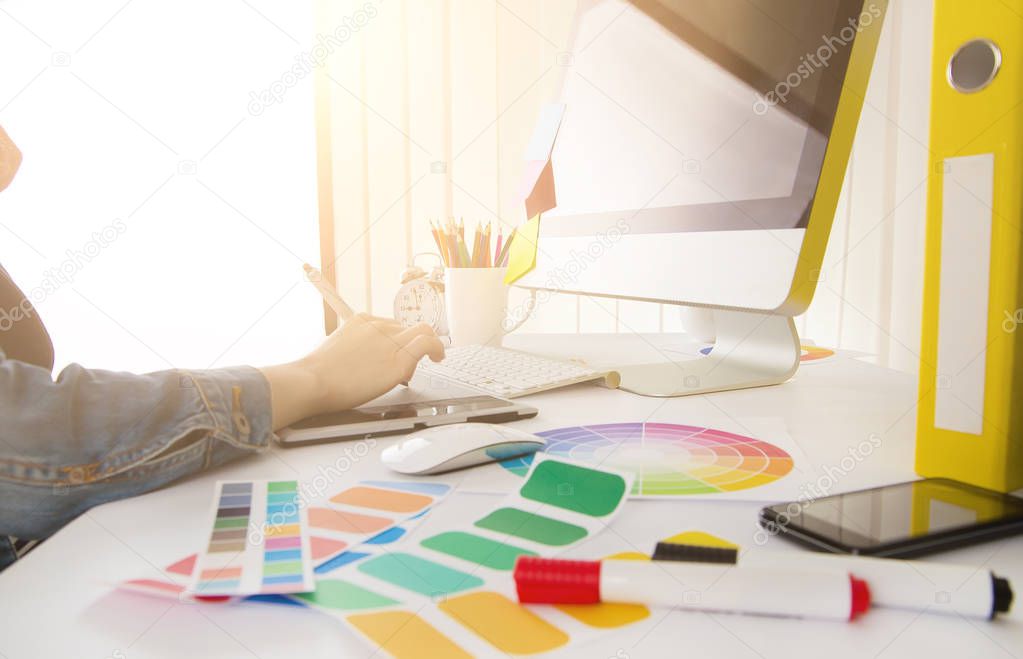 Young woman graphic designer using graphics tablet to do his work at desk
