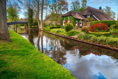 Harika seyahat yerleştirin, tipik Hollanda kırsal konutlarında süs bahçeleri ve su kanalı, Giethoorn, Hollanda, Avrupa üzerindeki ahşap köprü