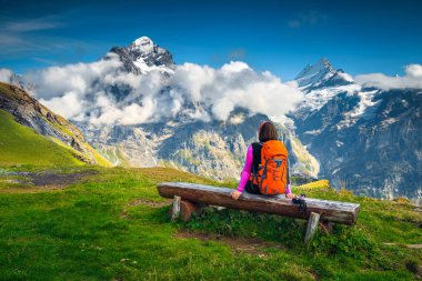 Wetterhorn Dağları, buzul ve Grindelwald, Bernese Oberland, İsviçre, Europe yakınındaki yeşil alanları ile çarpıcı panorama sportif uzun yürüyüşe çıkan kimse kadının bankta, rahatlatıcı