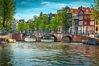 Fantastik seyahat ve Turizm hedef, geleneksel Hollanda evleri ile muhteşem cityscape. Kanal tekne ile su ve nehir, Amsterdam, Hollanda, Avrupa üzerinde köprü