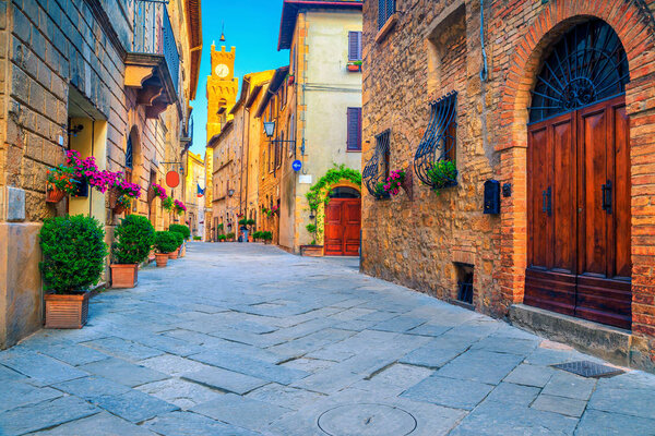 Spectacular traditional Tuscany street view. Admirable medieval stone houses and paved street with flowery entrances, Pienza, Tuscany, Italy, Europe