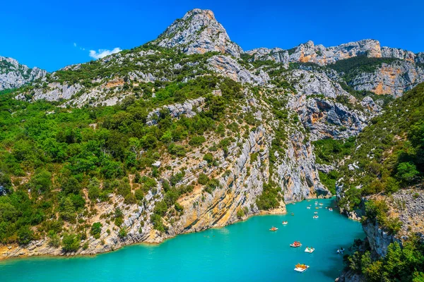 Famous outdoor recreation place with boats, kayaks and canoes. Summer holiday destination with lake and high cliffs in Verdon gorge, Provence, France, Europe