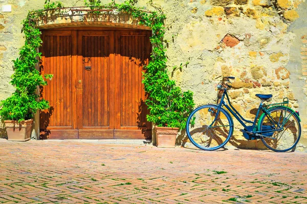 Toscane straat met bloemrijke entree en retro fiets, Pienza, Italië — Stockfoto