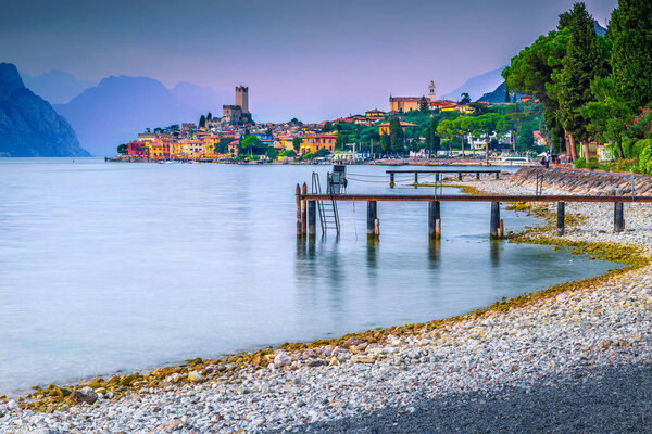 Wonderful summer vacation and relaxation resort, Malcesine touristic place, breathtaking gravel beach at sunset, Garda lake, Veneto region, Italy, Europe