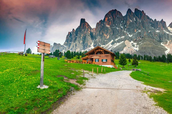 Útulné alpské chaty a dřevěné turistické vývěsní štít v regionu Dolomity, Itálie — Stock fotografie