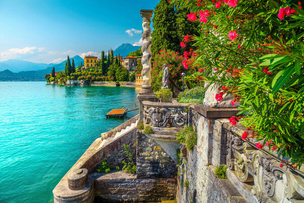 Picturesque landscape with lake and mediterranean buildings. Fresh oleander flowers and beautiful ornamental garden with villa Melzi, lake Como, Varenna, Lombardy region, Italy, Europe
