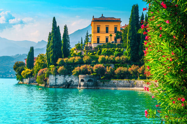 Beautiful landscape with blue lake and mediterranean buildings. Fragrant oleander flowers and stunning ornamental garden with villa Melzi, lake Como, Varenna, Lombardy region, Italy, Europe