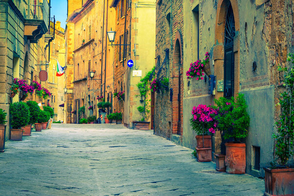 Picturesque traditional Tuscany street view. Beautiful medieval stone houses and paved street with flowery entrances, Pienza, Tuscany, Italy, Europe