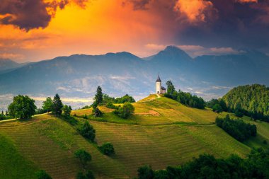 Alpine sunset landscape with Saint Primoz church, near Jamnik, Slovenia clipart