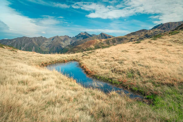 Spektakulär alpin damm med höga toppar i bakgrunden, Transylvania, Rumänien — Stockfoto