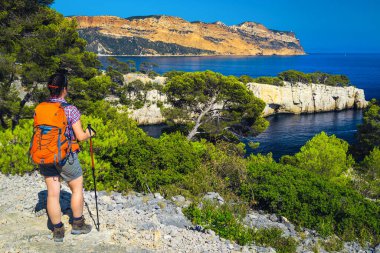 Sırt çantalı sporcu kadın Calanques Ulusal Parkı, Cassis, Provence, Fransa, Avrupa 'daki yürüyüş parkından mavi su koyuyla manzaranın keyfini çıkarıyor.