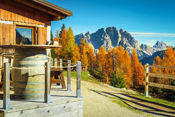 Cozy accommodation place with wooden house in the mountains. Fantastic recreation and hiking location in the colorful autumn forest, Dolomites, Italy, Europe