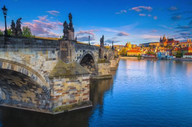 Prag 'daki ünlü binaların olduğu güzel bir sabah sahnesi. Güneş doğarken Vltava nehrinin üzerindeki eski Charles köprüsü, Prag, Çek Cumhuriyeti, Avrupa