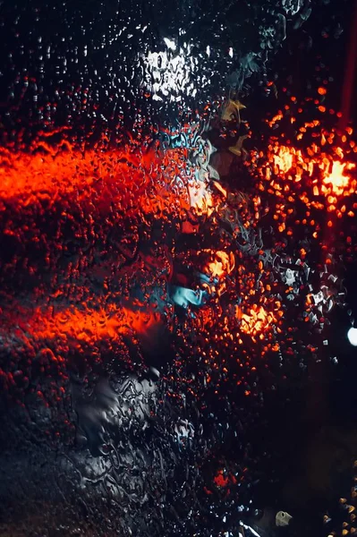 rain and lights on the window at night in the street
