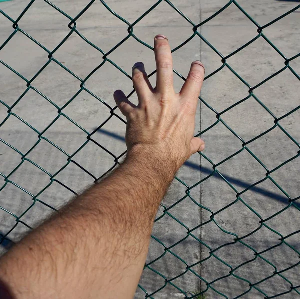 Mann Greift Mit Der Hand Nach Einem Metallzaun Auf Der — Stockfoto