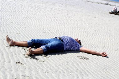 Beyaz kum plaj giysileri içinde yatan bir adam görüntüsü