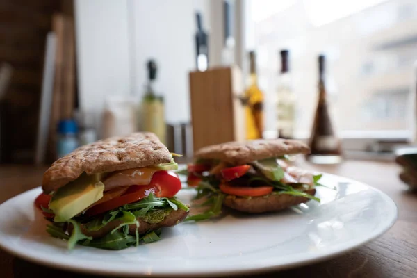 Verse zalm sandwich met salade close-up en avocado en een wit bord Stockfoto