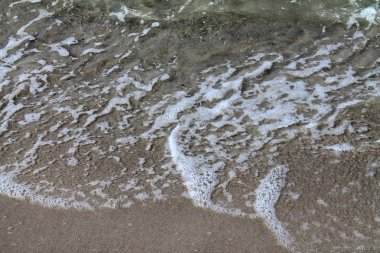 Yüzey su dalgaları ve Yüzüklerin plajda kapatın