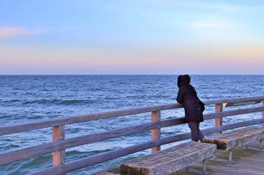 Kumsalda bir yürüyüşe rüzgarlı bir Aralık gününde insanlar