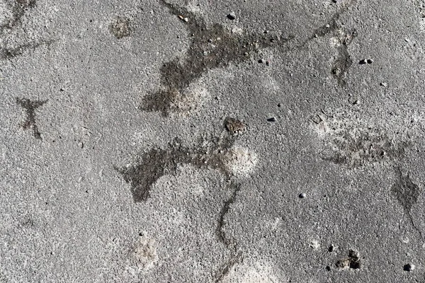 Detailed close up surface of asphalt on streets with small stones and cracks