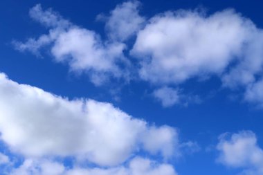 Derin mavi gökyüzünde güzel kabarık beyaz Cumulus ve Cirrus bulutlar