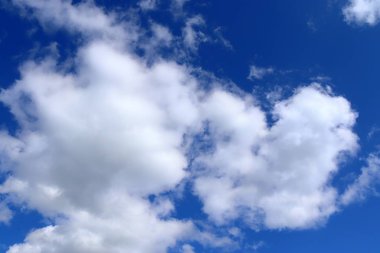 Derin mavi gökyüzünde güzel kabarık beyaz Cumulus ve Cirrus bulutlar