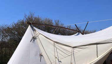 Mavi gökyüzünün önünde bez ve ahşaptan yapılmış eski vikingçadırı