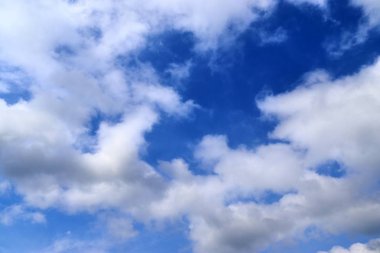 Güzel kabarık beyaz bulutlar derin mavi gökyüzünde güneş ışığı ile kaplı