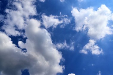 Güzel kabarık beyaz bulutlar derin mavi gökyüzünde güneş ışığı ile kaplı