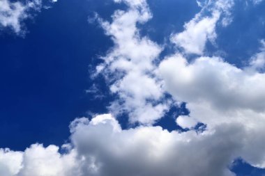 Güzel kabarık beyaz bulutlar derin mavi gökyüzünde güneş ışığı ile kaplı