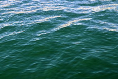 Dalgalar ve dalgalar ve bazı yansımaları ile yüzen su yüzeyini kapatın