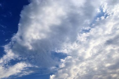 Mavi bir gökyüzünde güzel karışık beyaz ve karanlık bulut oluşumları