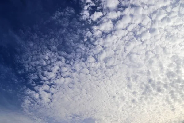 在深蓝色的天空中美丽的蓬松白云 — 图库照片