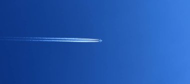 Derin mavi gökyüzündeki uçak izlerinin ayrıntılı görünümü