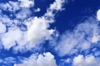 Derin mavi gökyüzünde kabarık beyaz bulutlar üzerinde rahatlatıcı görünümü