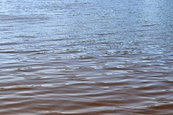 Close up view on a reflective water surface with waves and ripples in high resolution