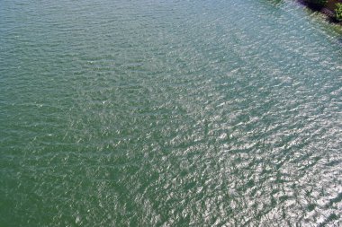 Dalgalar ve dalgalanmalar üzerinde güneş ışığı yansıtan su yüzeyleri üzerinde ayrıntılı yakın görünüm