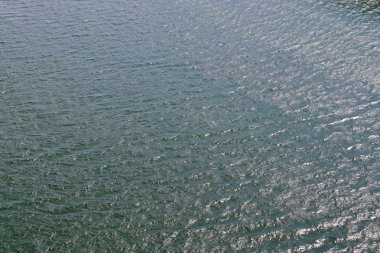 Dalgalar ve dalgalanmalar üzerinde güneş ışığı yansıtan su yüzeyleri üzerinde ayrıntılı yakın görünüm