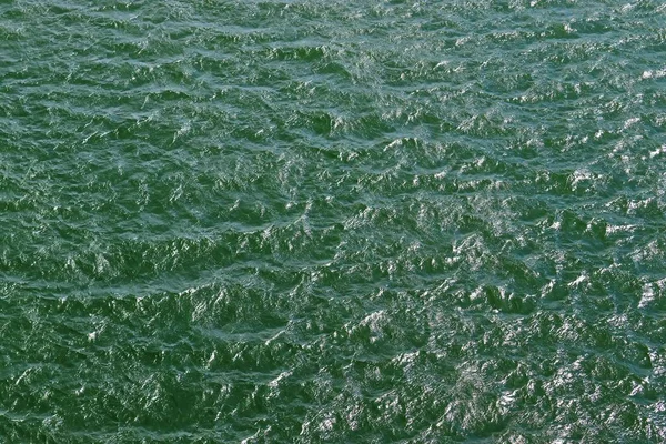 Dalgalar ve dalgalanmalar üzerinde güneş ışığı yansıtan su yüzeyleri üzerinde ayrıntılı yakın görünüm