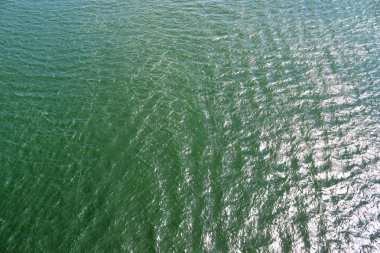 Dalgalar ve dalgalanmalar yansıma güneş ışığı ile su yüzeyinde ayrıntılı yakın görünümü