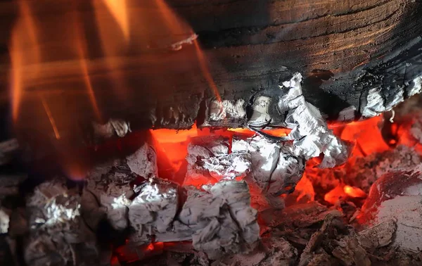 Turuncu alevler ve közler ile güzel sıcak yanan kamp ateşi yakından görünümünde