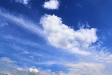 Derin mavi yaz gökyüzünde dramatik ve kabarık beyaz bulutlar