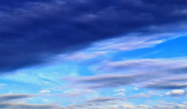 Stunning mixed cloud formation panorama on a deep blue summer sky