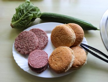 Domatesli ve salatalı ızgara hamburgerden ev yapımı..