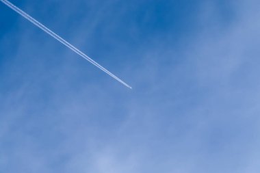 Hava aracının yoğunlaşması mavi gökyüzünde bazı güzel bulutların arasında zıt düşer.