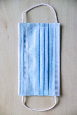 Açık mavi tıbbi maske, ağzı ve burnu kapamak için lastik kulaklıklar. Virüs ve bakterilerin prosedür maskesi.