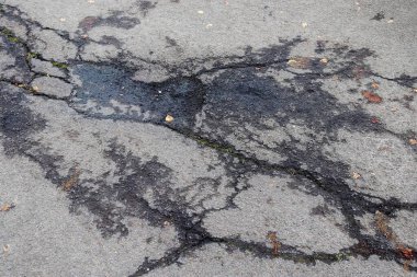 Farklı caddelerin ve yolların asfalt yüzeylerinin detaylı görüntüsü ve yakın plan çatlakları