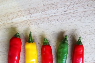 Ahşap kesme tahtasındaki kırmızı biber ve bıçağın izole edilmiş arka planda üst ve perspektif görüntüsü