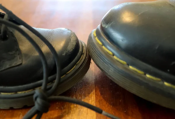 Μεγάλο Και Μικρό Μαύρο Δερμάτινο Παπούτσι Ξύλινο Πάτωμα — Φωτογραφία Αρχείου